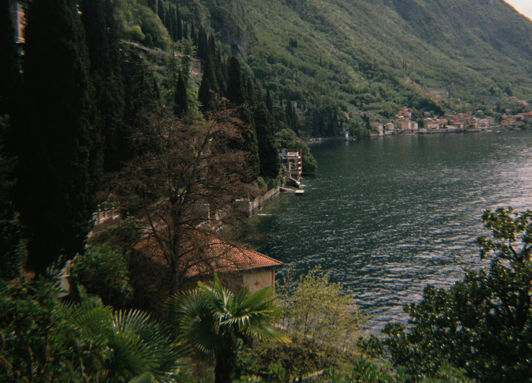 A picturesque view over Lake Como surrounded by lush hills and trees.