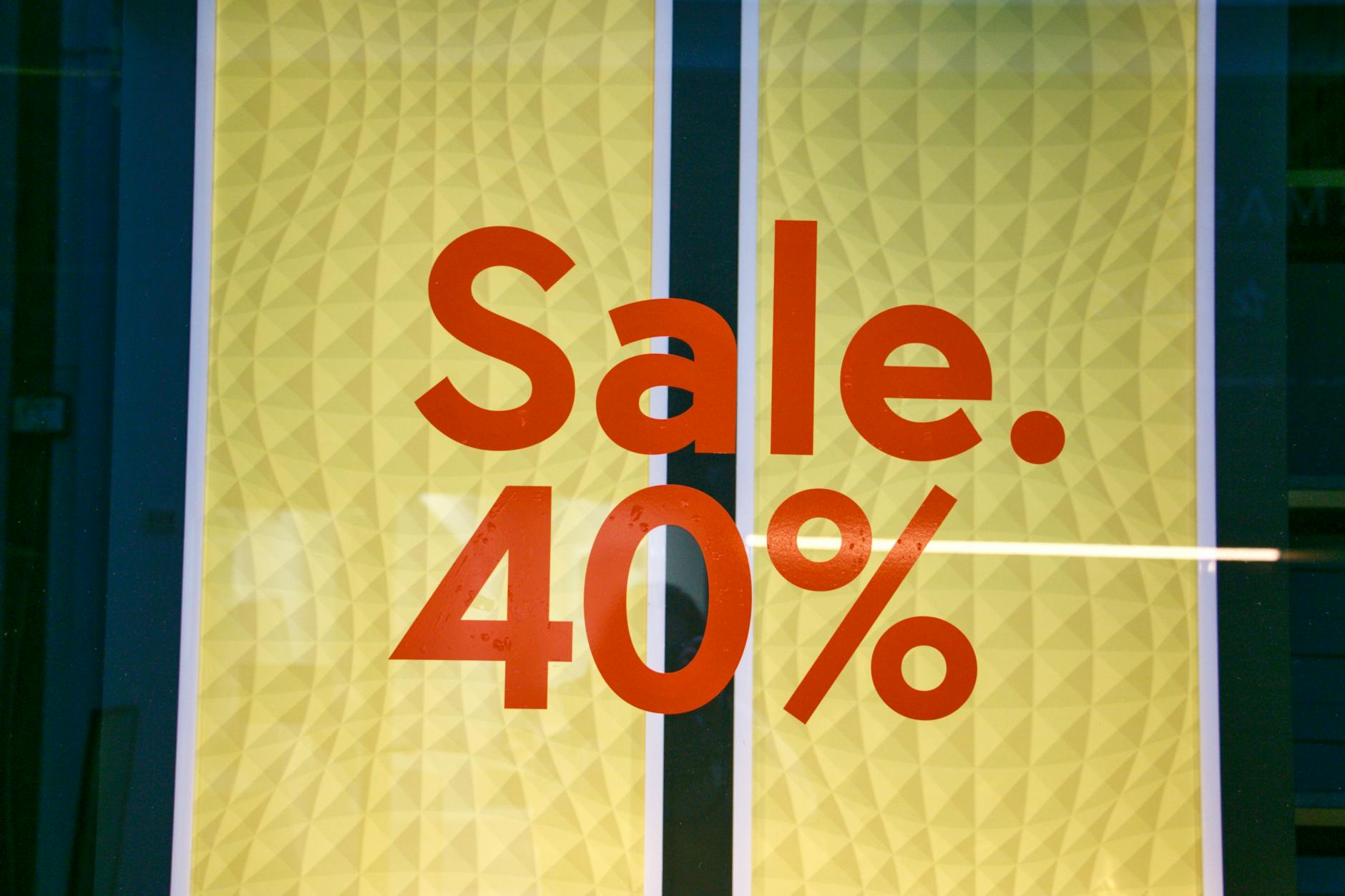 Bright retail sale sign showing 40 percent discount on yellow background.