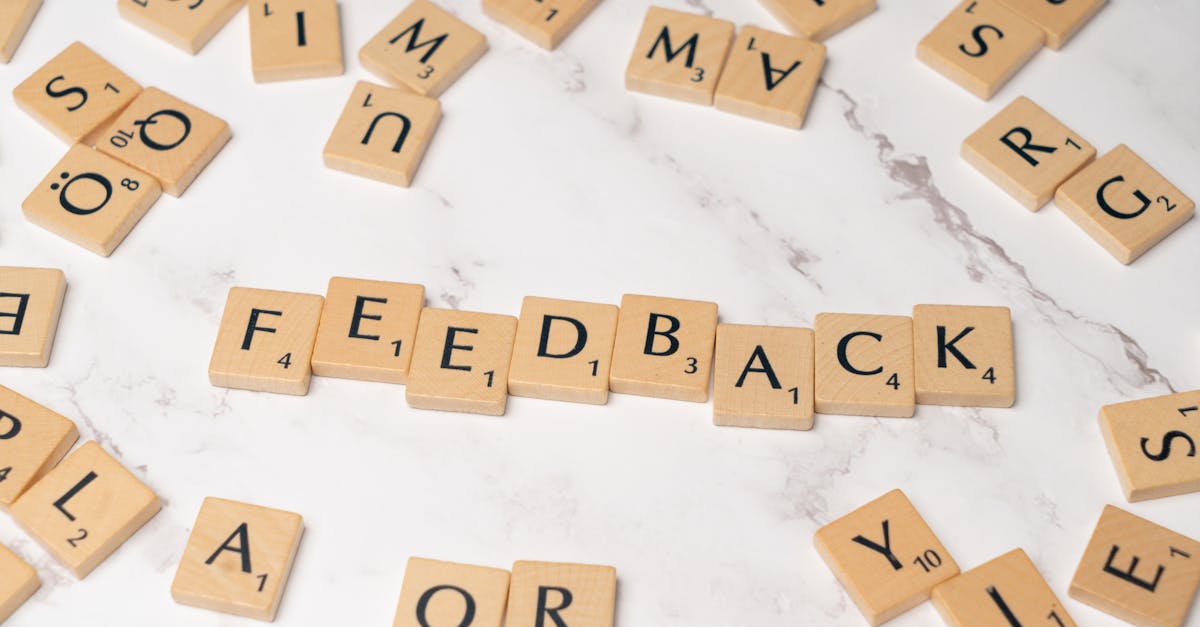Wooden Scrabble tiles arranged to spell 'Feedback' on a marble background.
