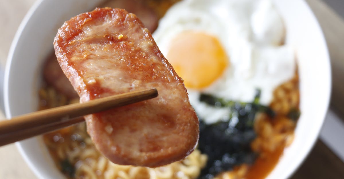 Close-up of a tasty noodle bowl with fried egg and Spam, perfect Asian cuisine delight.