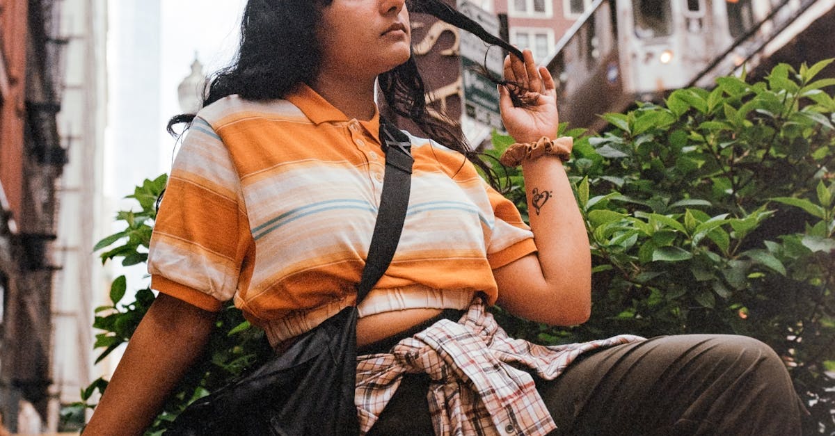Stylish woman sitting outdoors in Chicago, with the CTA train in the background, capturing urban vibes.