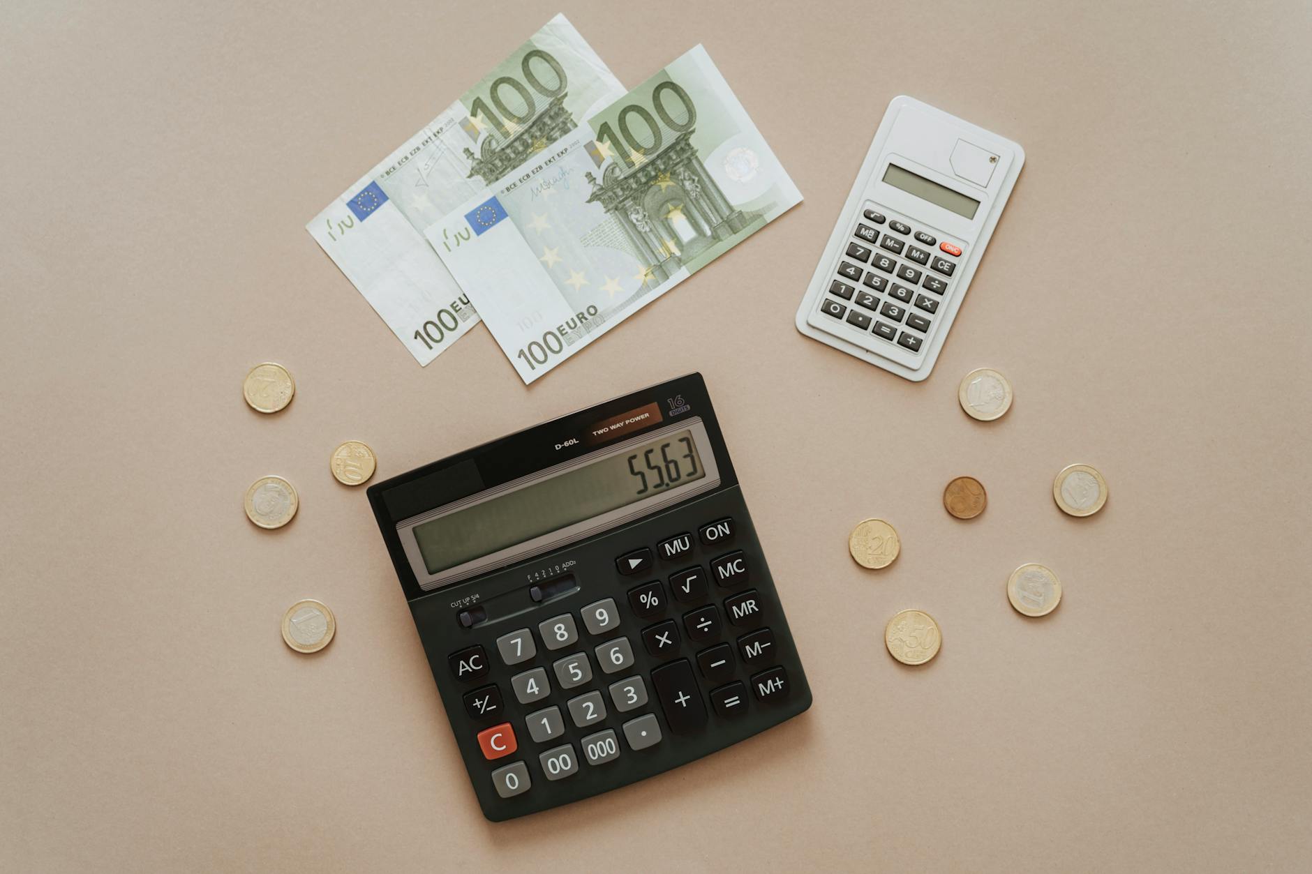 Flat lay of calculators and Euro currency, depicting financial calculations and budget management.