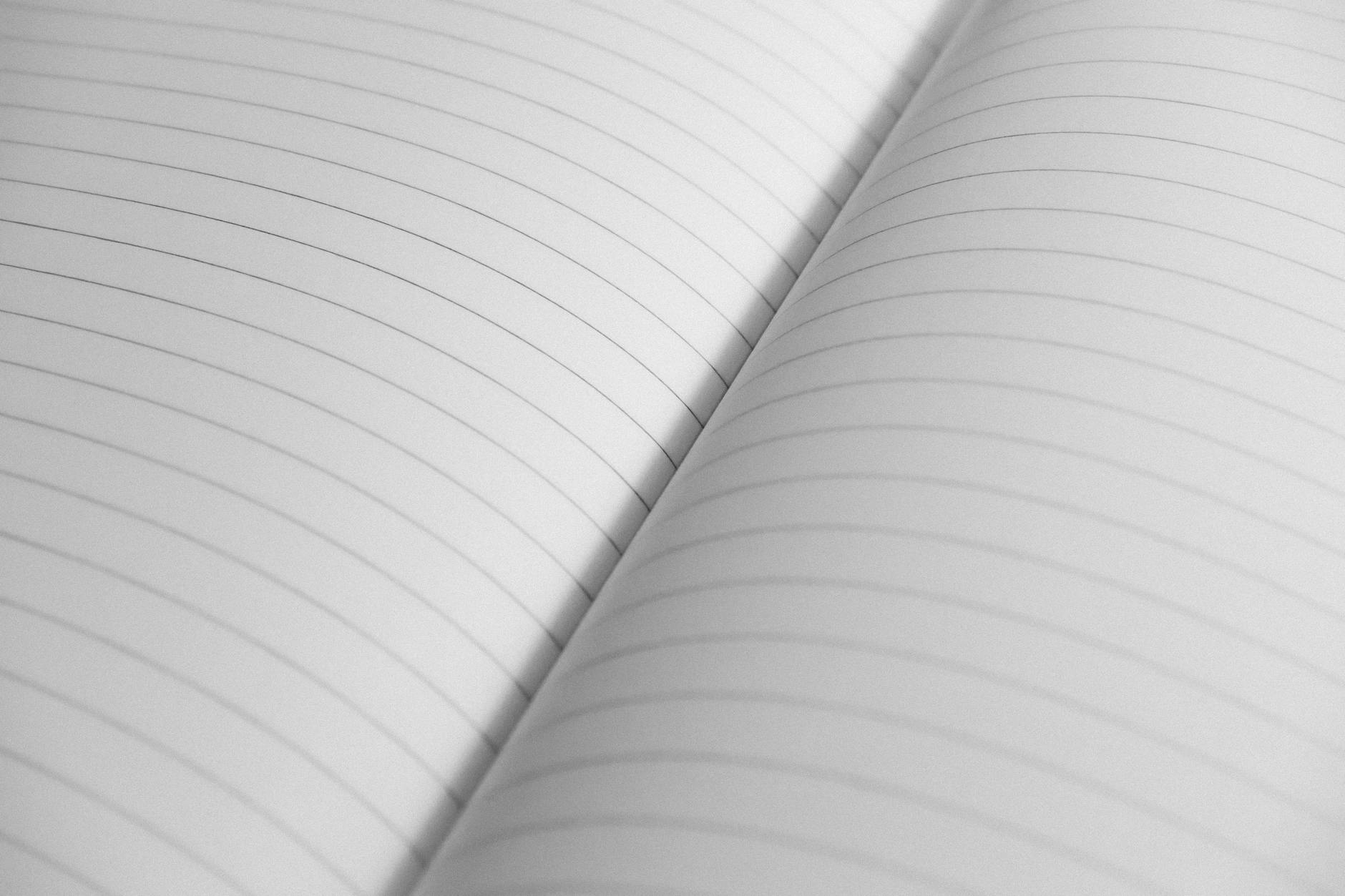 High-resolution close-up of an open notebook with lined pages, perfect for stationery concepts.