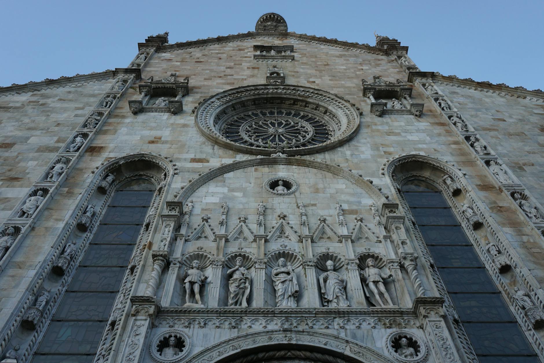 Low-angle view of the intricate Gothic facade of Como Cathedral in Italy.