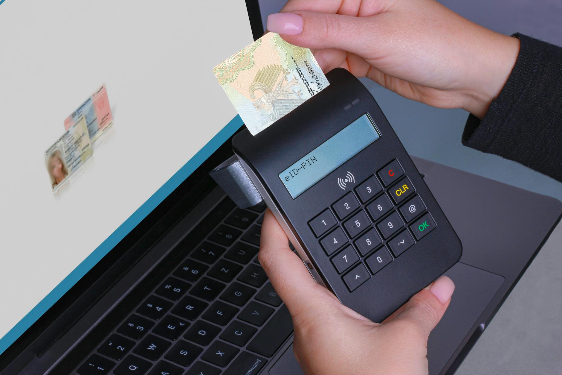 Person using contactless device for ID payment verification on a laptop.