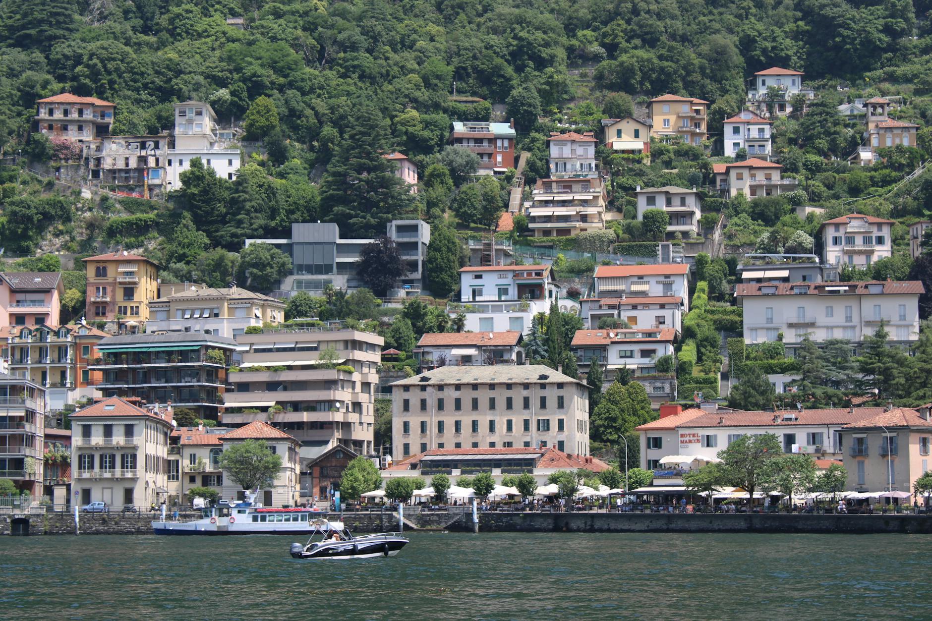 Picturesque hillside buildings by Lake Como surrounded by lush greenery.