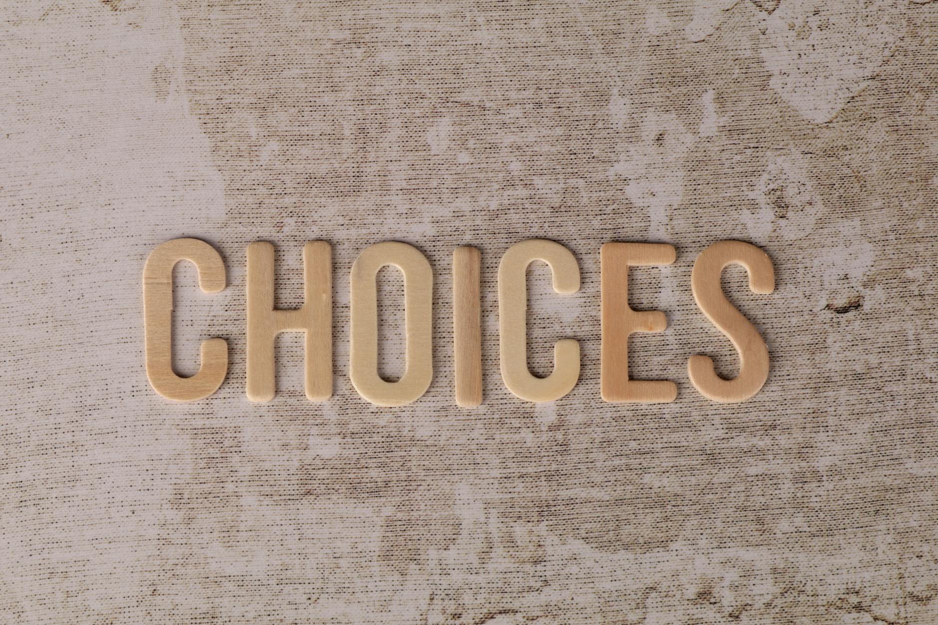Wooden letters spelling 'choices' on a textured surface, symbolizing decision-making.