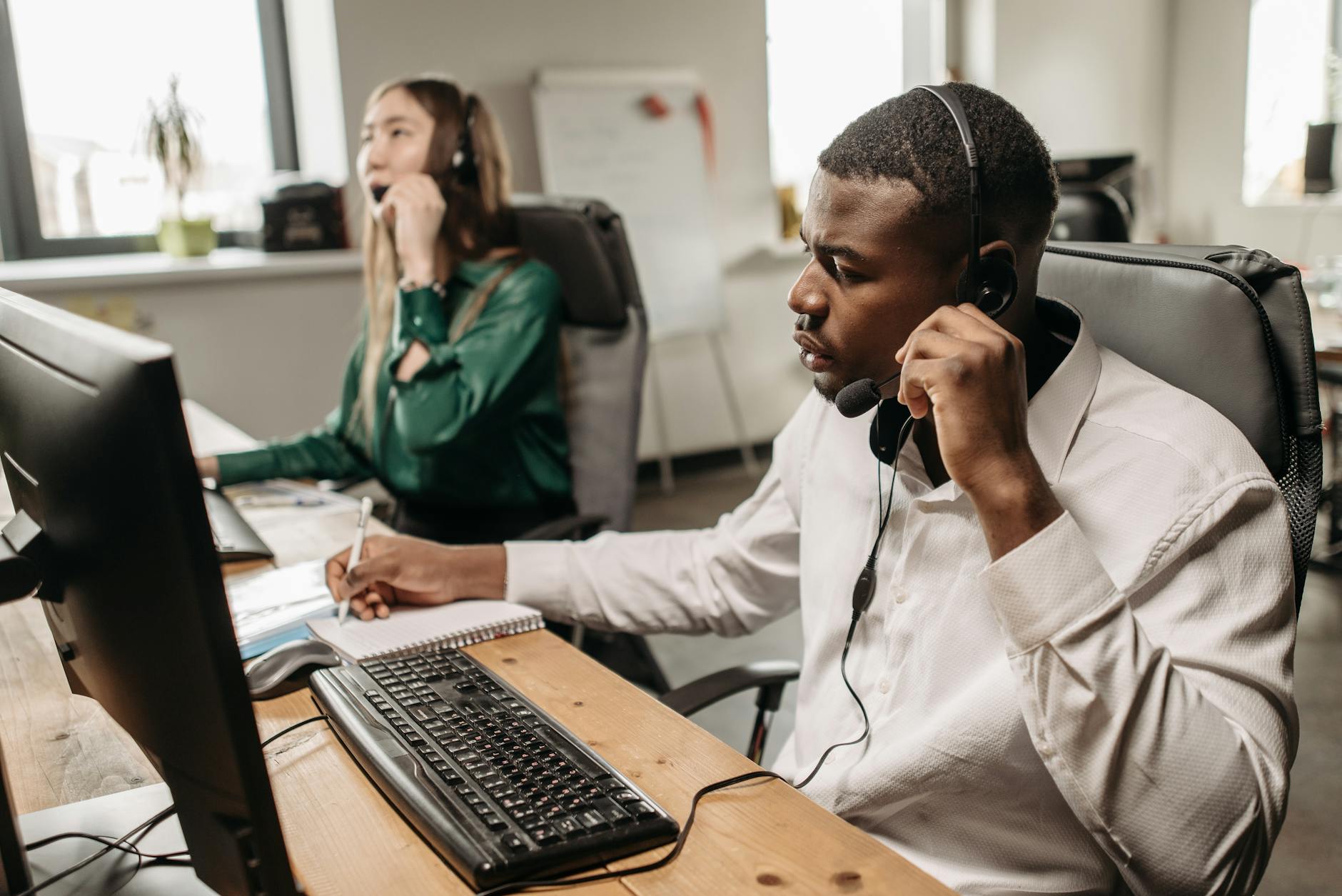 A focused team of customer service representatives working on computers and answering calls in an office