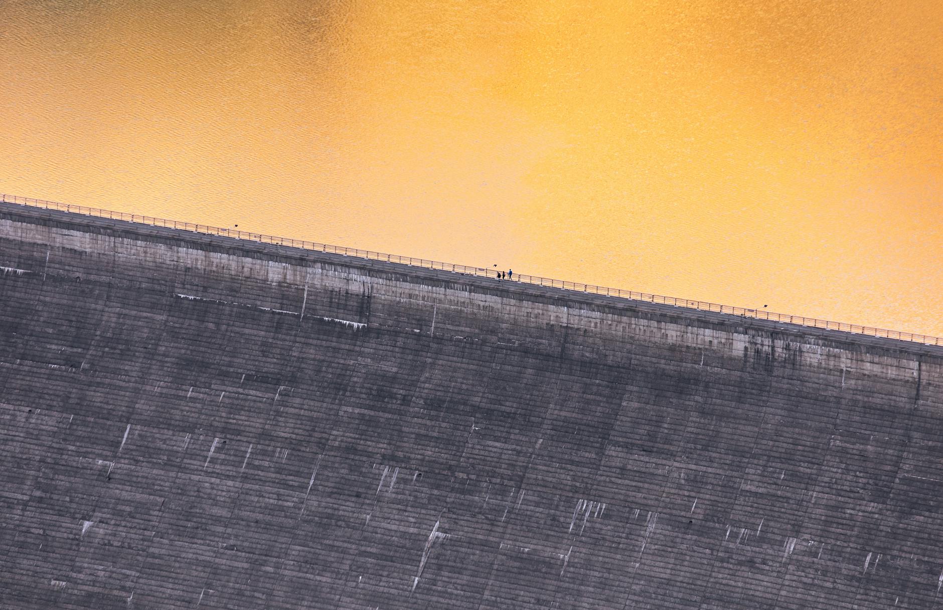 A stunning aerial shot of Alpe Gera Dam during sunrise, capturing the serene water and architectural marvel.