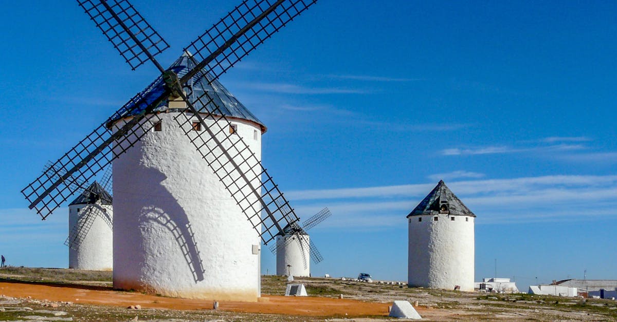 Captivating view of historic windmills under a vivid blue sky in Campo de Criptana, Spain.