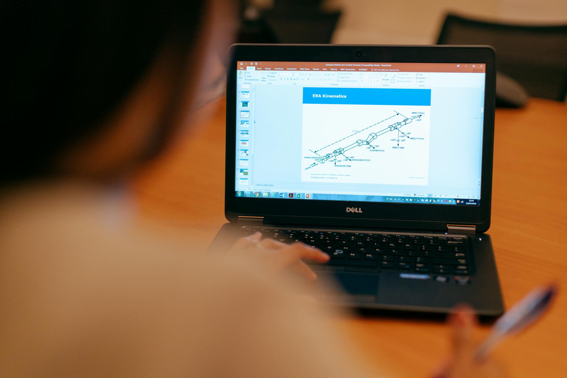 Female engineer working on laptop reviewing technical engineering presentation.