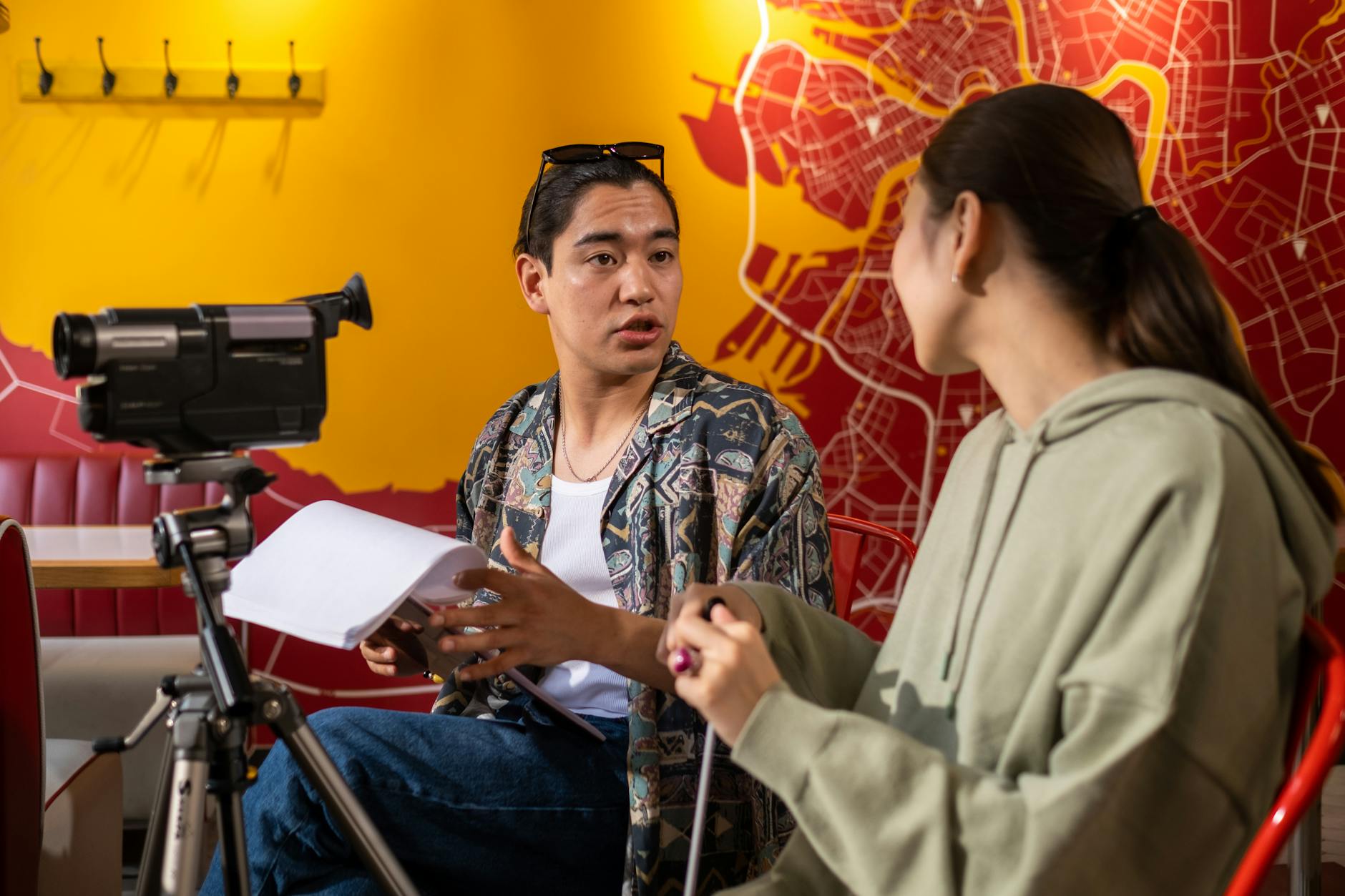 Young filmmakers in active discussion during a video shoot indoors.